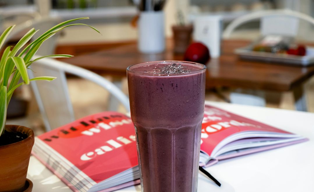 A woman enjoying a smoothie made with adaptogenic herbs, supporting stress relief and hormonal balance.