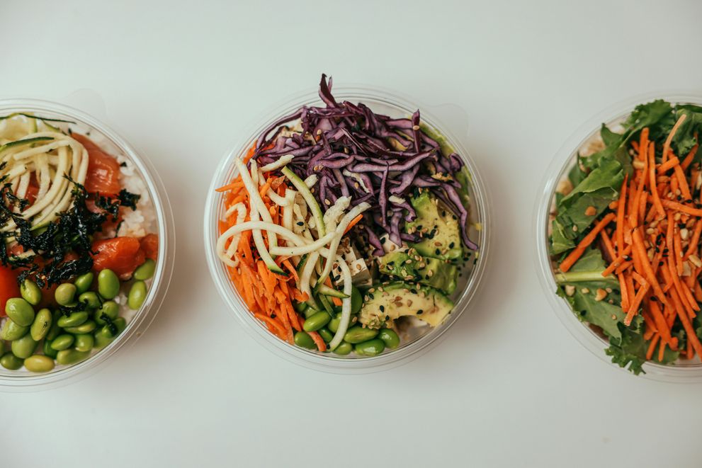 An assortment of anti-inflammatory foods, including berries, leafy greens, nuts, and salmon, arranged on a wooden table.