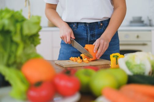 A Woman Is Cuttin A Bell Pepper