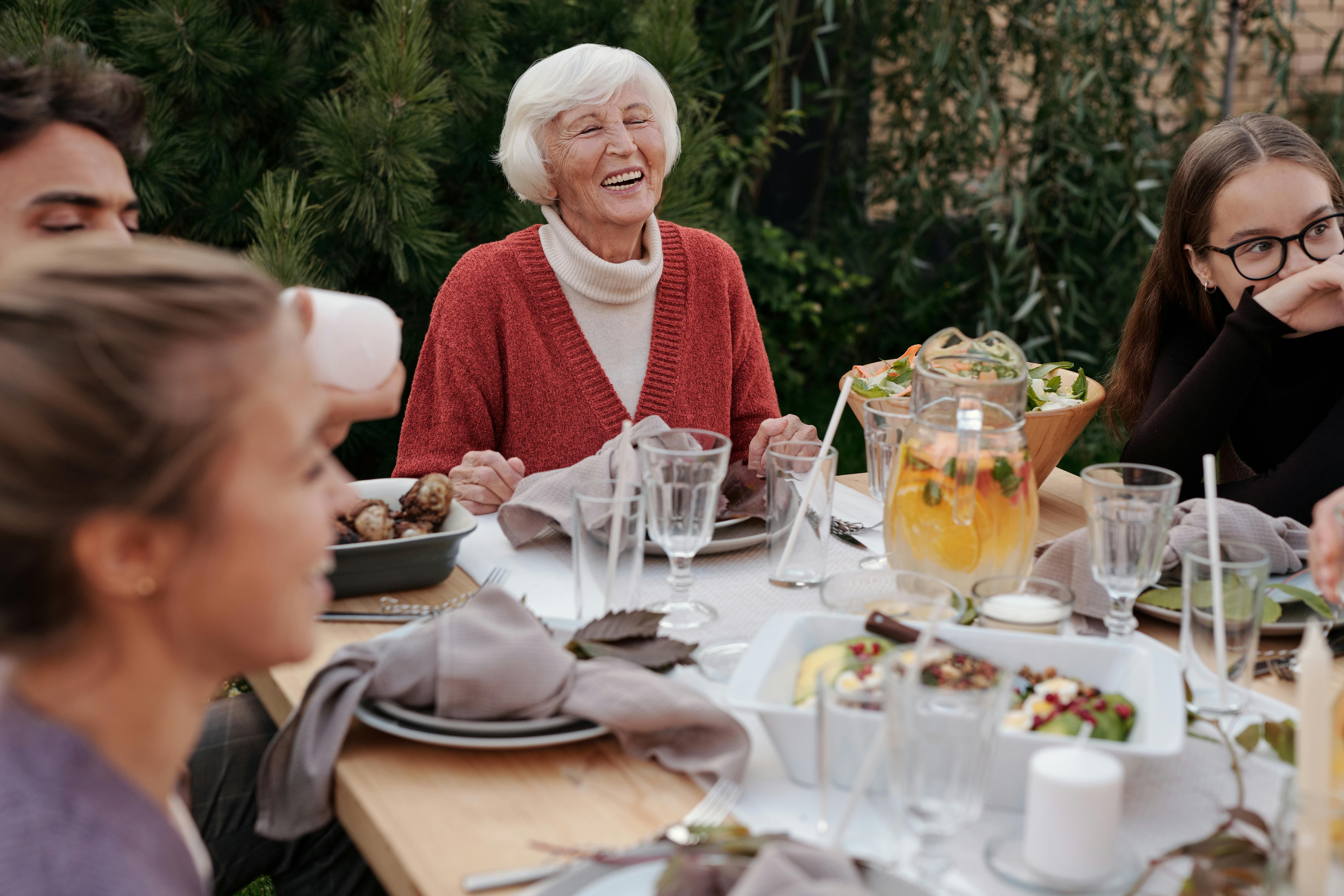 A group of Californian women from a Blue Zone region socializing and enjoying a healthy dinner in a garden, reflecting the importance of community and shared meals in longevity.