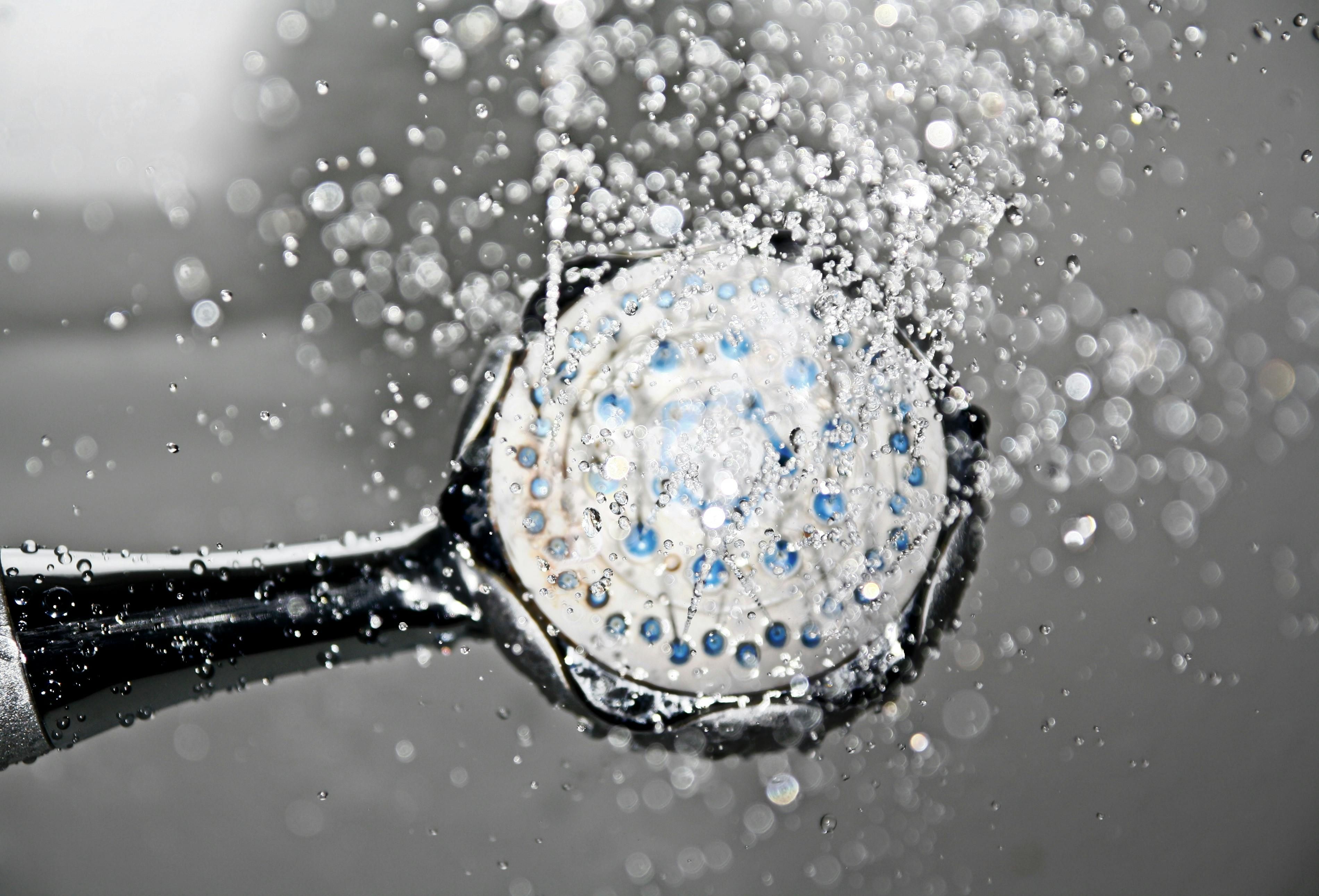 Cold water flowing from a showerhead, representing cold exposure techniques for weight loss.