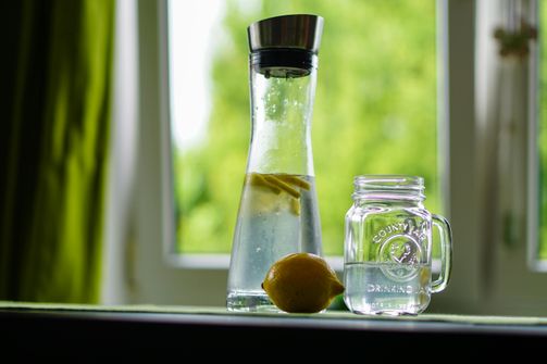 A woman sipping a detox beverage while considering the facts about detox drinks and natural body detoxification.