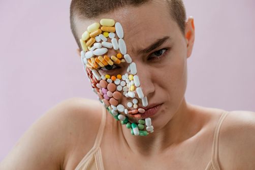 A woman taking an antibiotic pill while intermittent fasting, highlighting the balance between health and fasting goals.