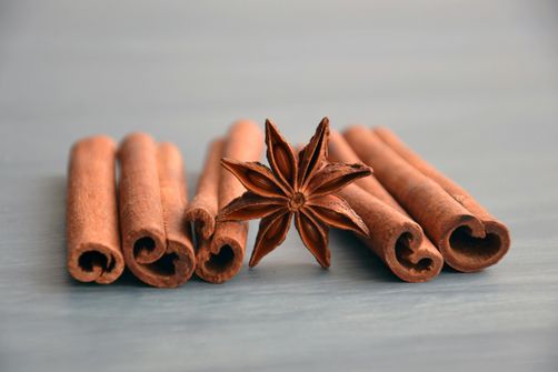 Cinnamon sticks and a cup of herbal tea, ideal for adding flavor during fasting windows