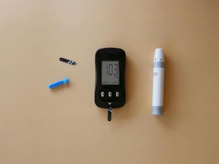 A person checking their blood glucose level during an intermittent fast, concerned about hypoglycemia