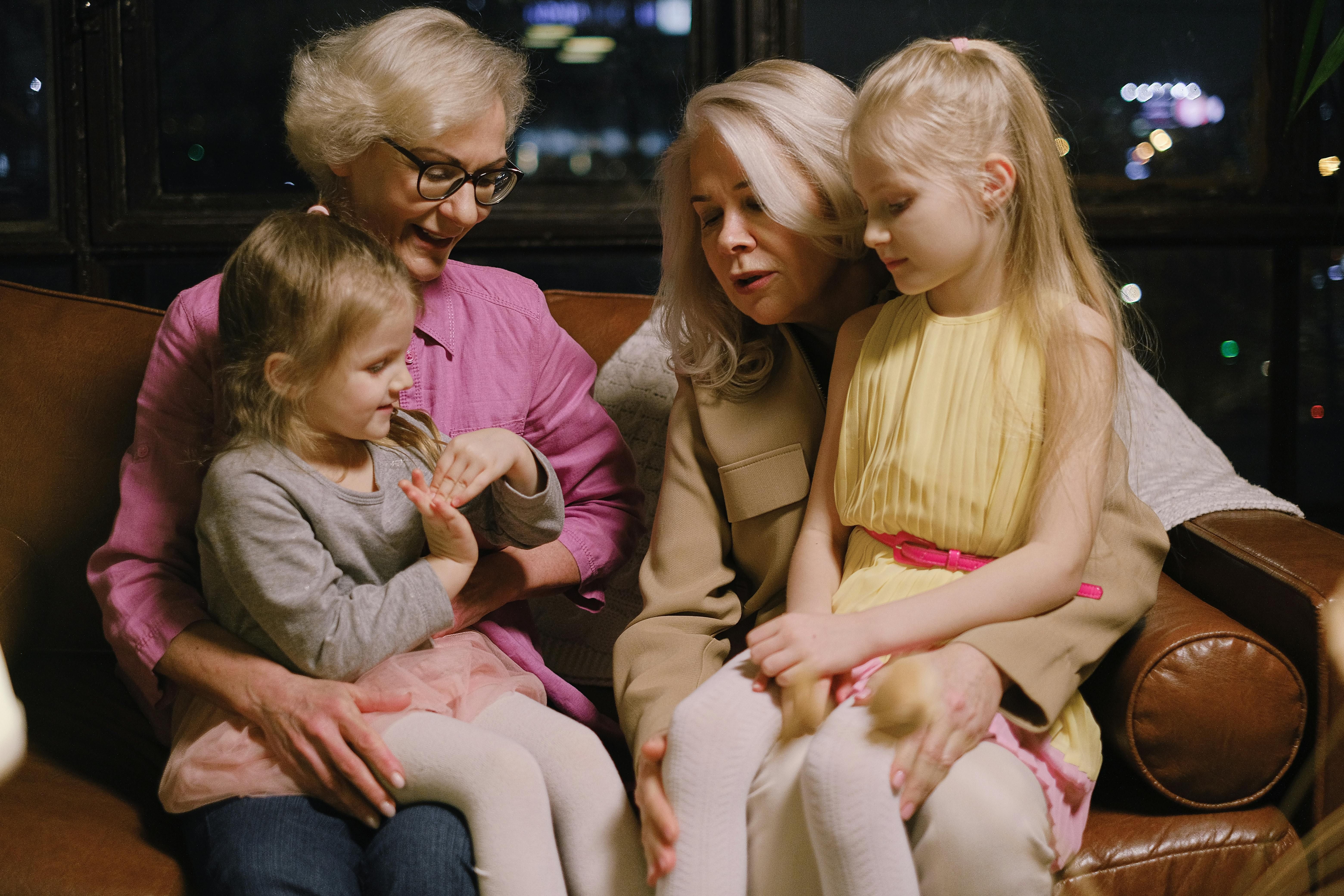 Two happy women over 60 enjoying playful moments with their granddaughters, celebrating family and togetherness