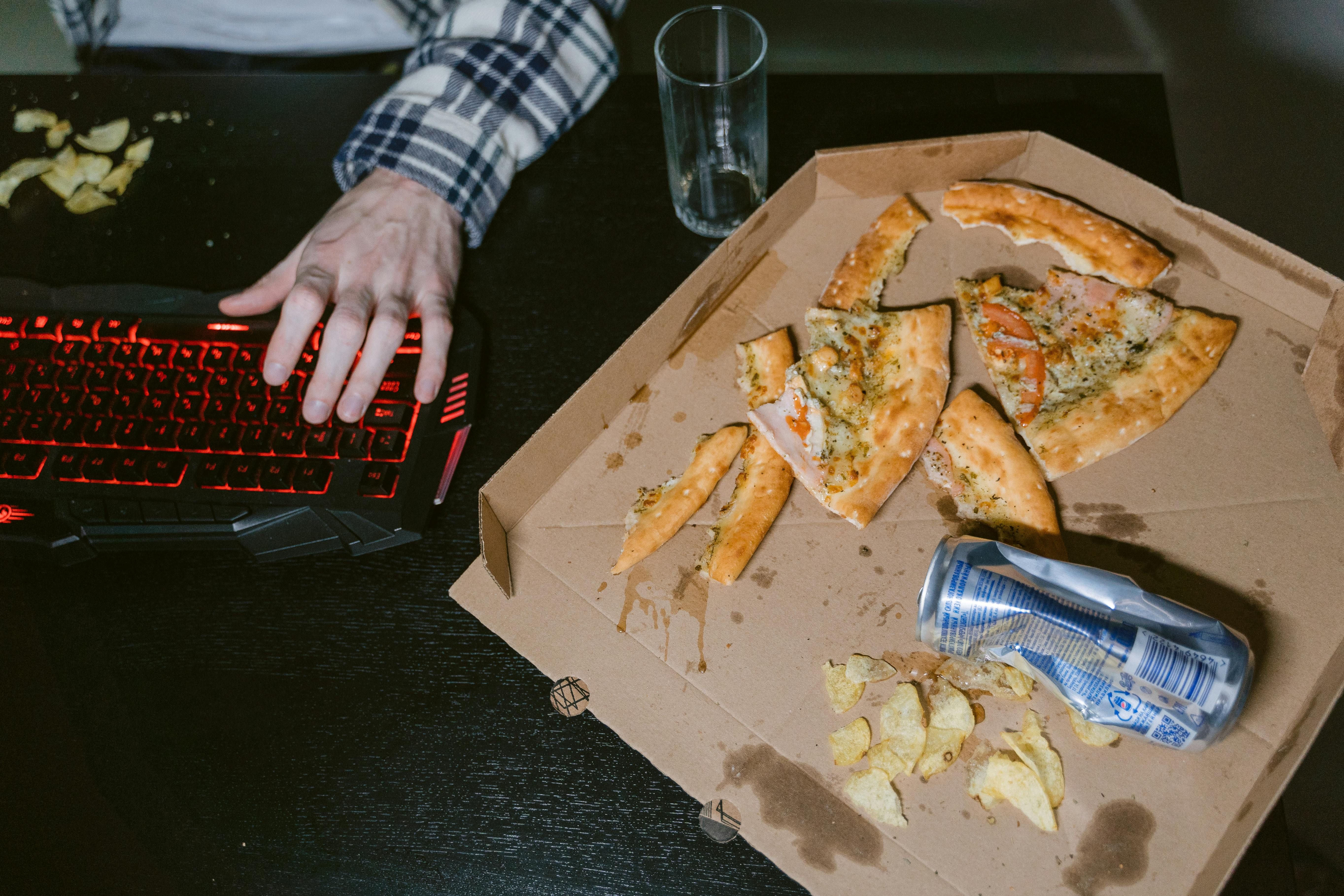 A person eating junk food during a night shift, highlighting unhealthy eating habits that can affect weight loss for shift workers.