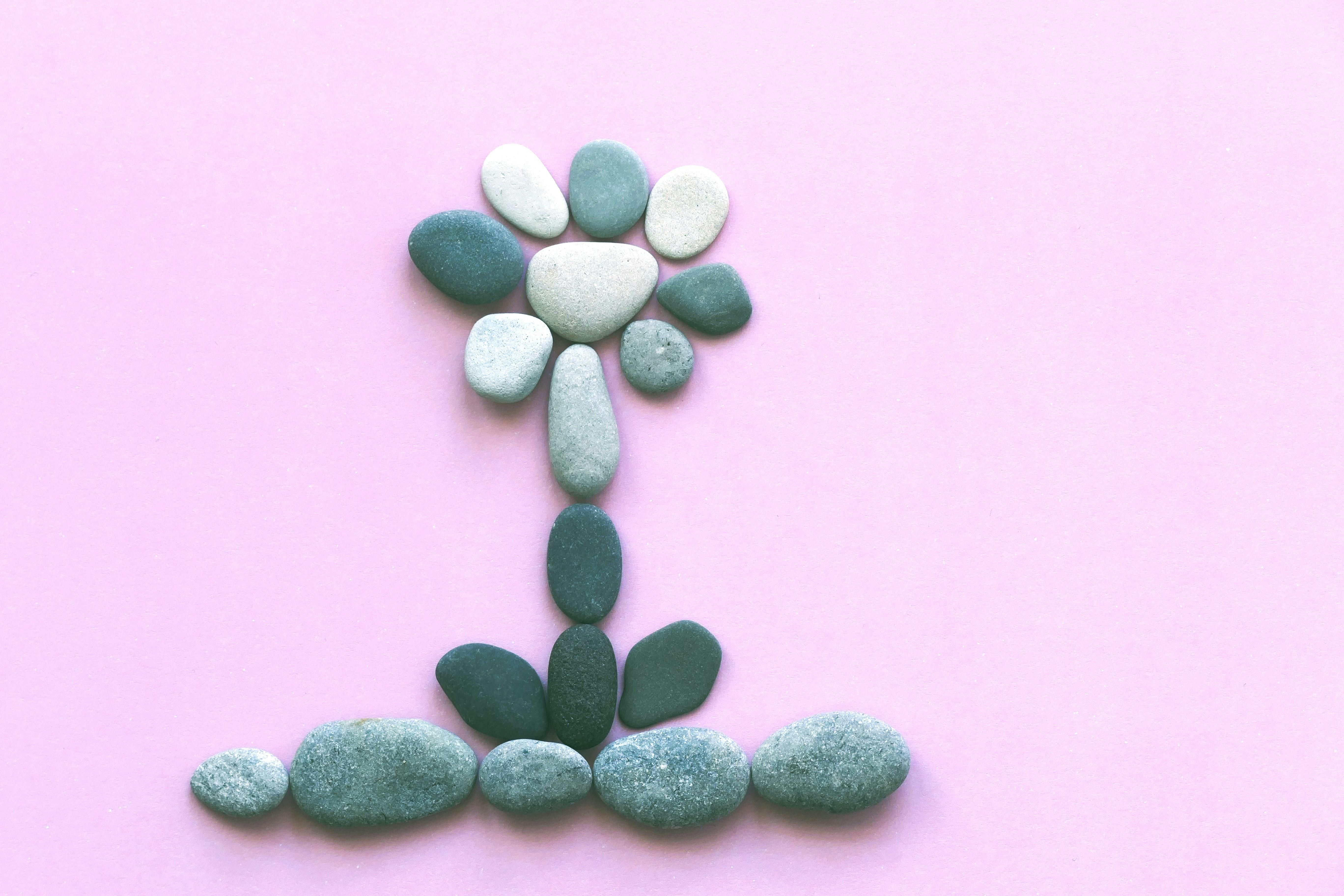 Close-up image of stones on a pink background symbolizing kidney stones, highlighting the importance of diet in kidney health.