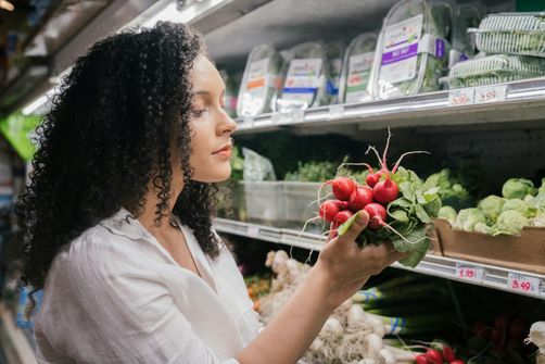 A woman choosing nutrient-rich foods to support mood and emotional well-being through diet.