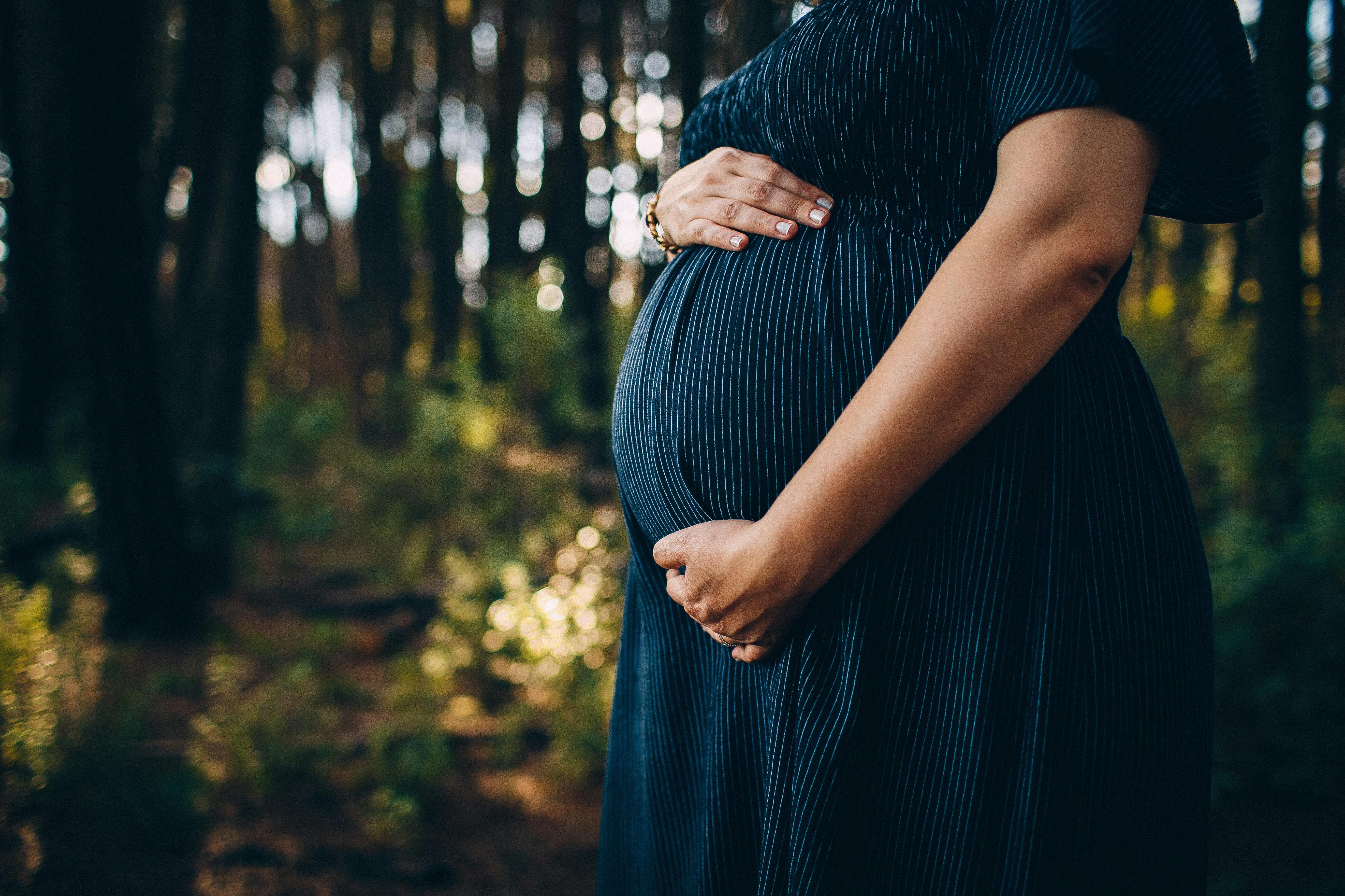 Radiant woman cradling her baby bump, a symbol of the beauty and anticipation of pregnancy