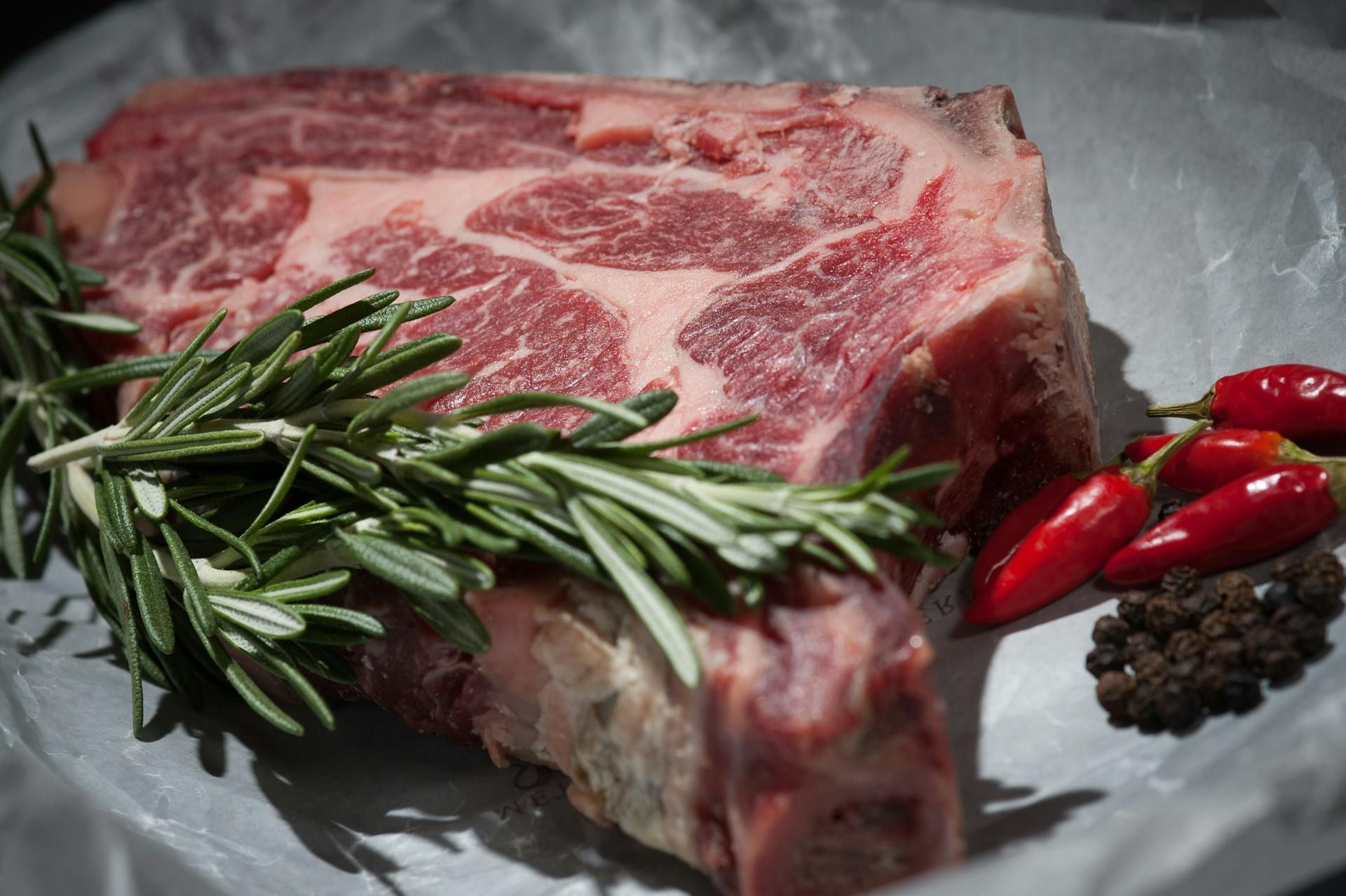 A perfectly cooked rib eye steak, showcasing its juicy and flavorful marbling, served on a wooden cutting board.