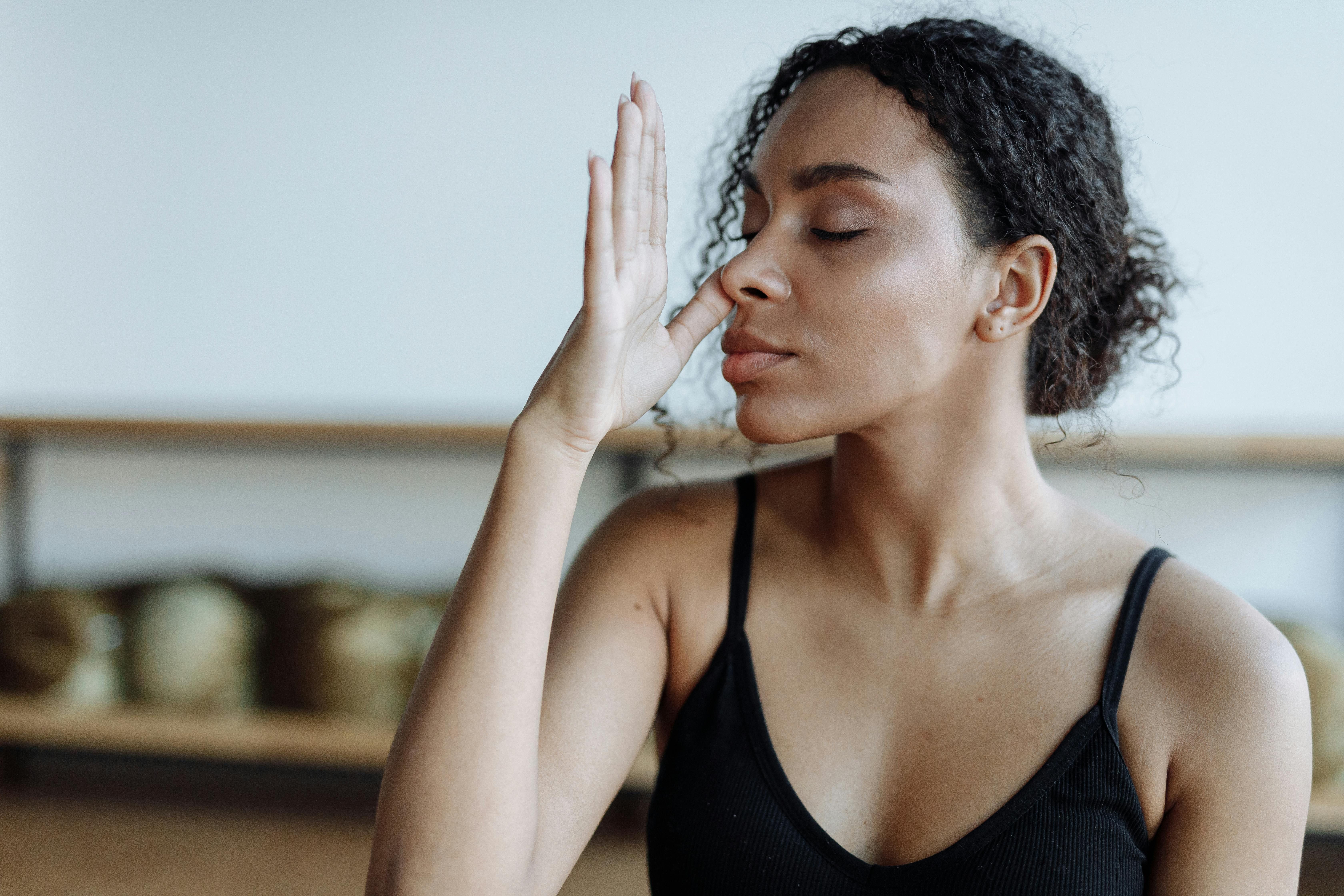 A woman practicing a breathing exercise to support weight loss, using controlled breathwork techniques for stress reduction and fat burning.