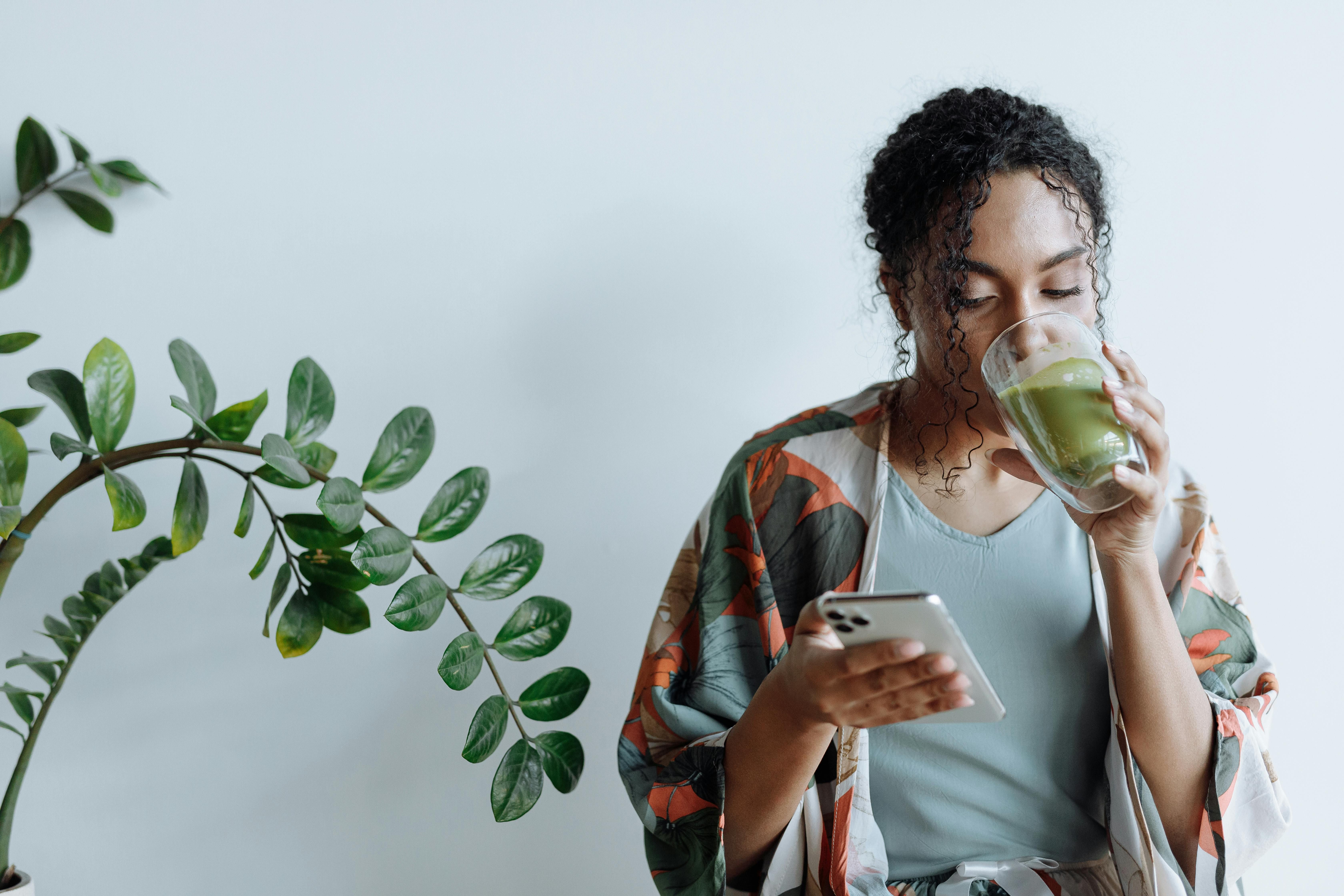 A woman enjoying a cup of matcha tea, promoting its benefits for weight loss and healthy living