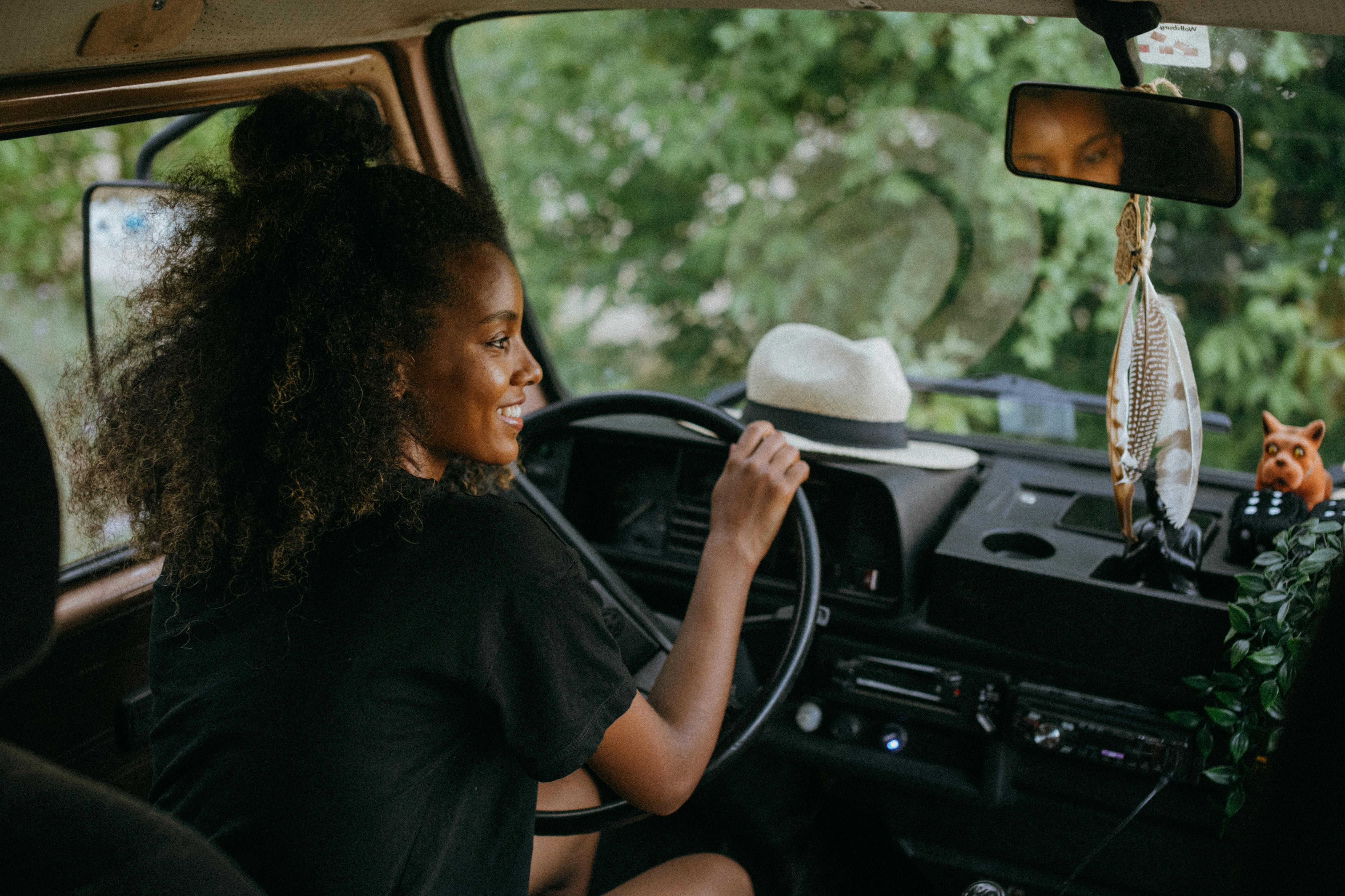 A woman driving her car while traveling, sticking to her carnivore diet with meal prep and snacks on the road.