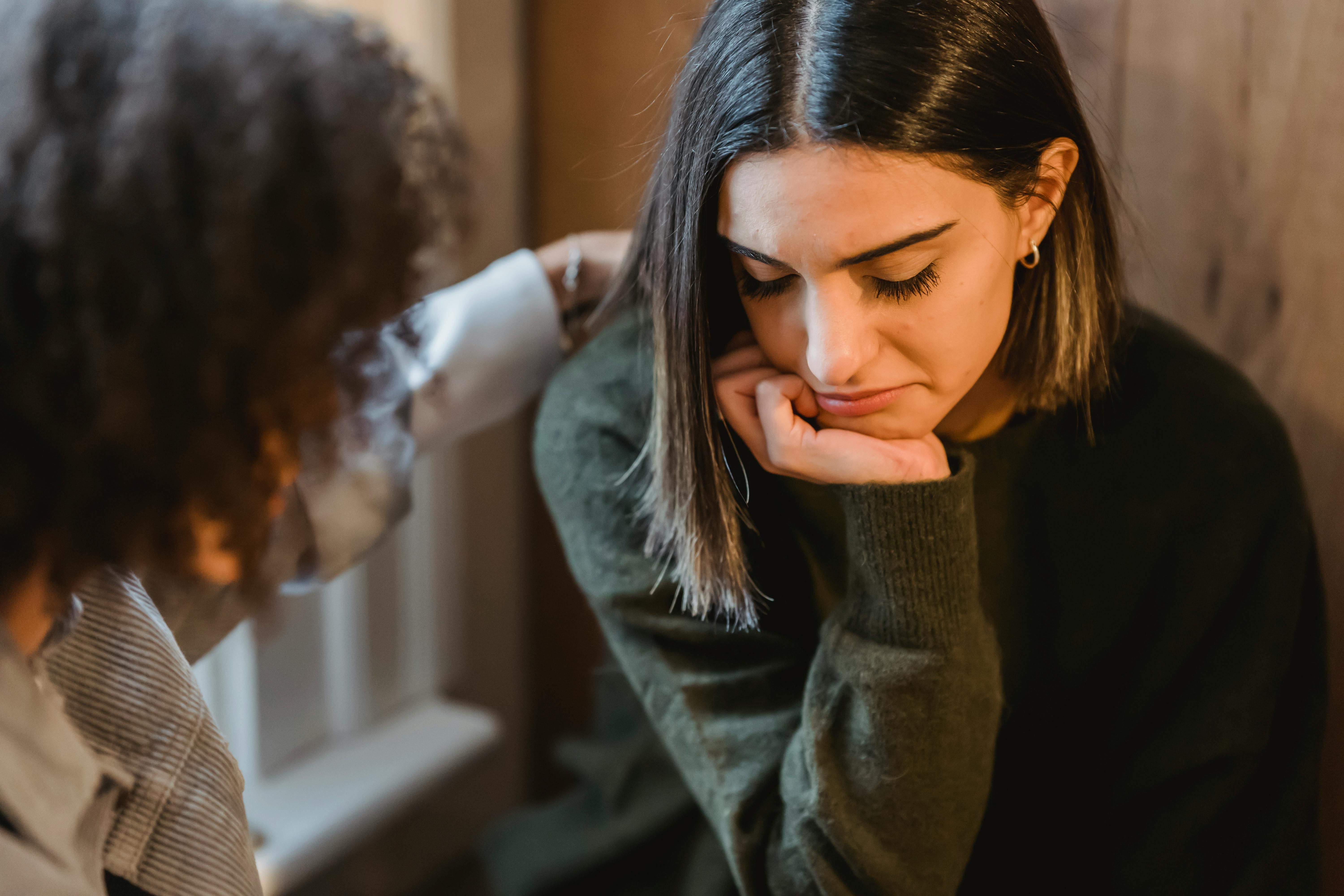 A compassionate woman providing reassurance to her friend struggling with anxiety while intermittent fasting