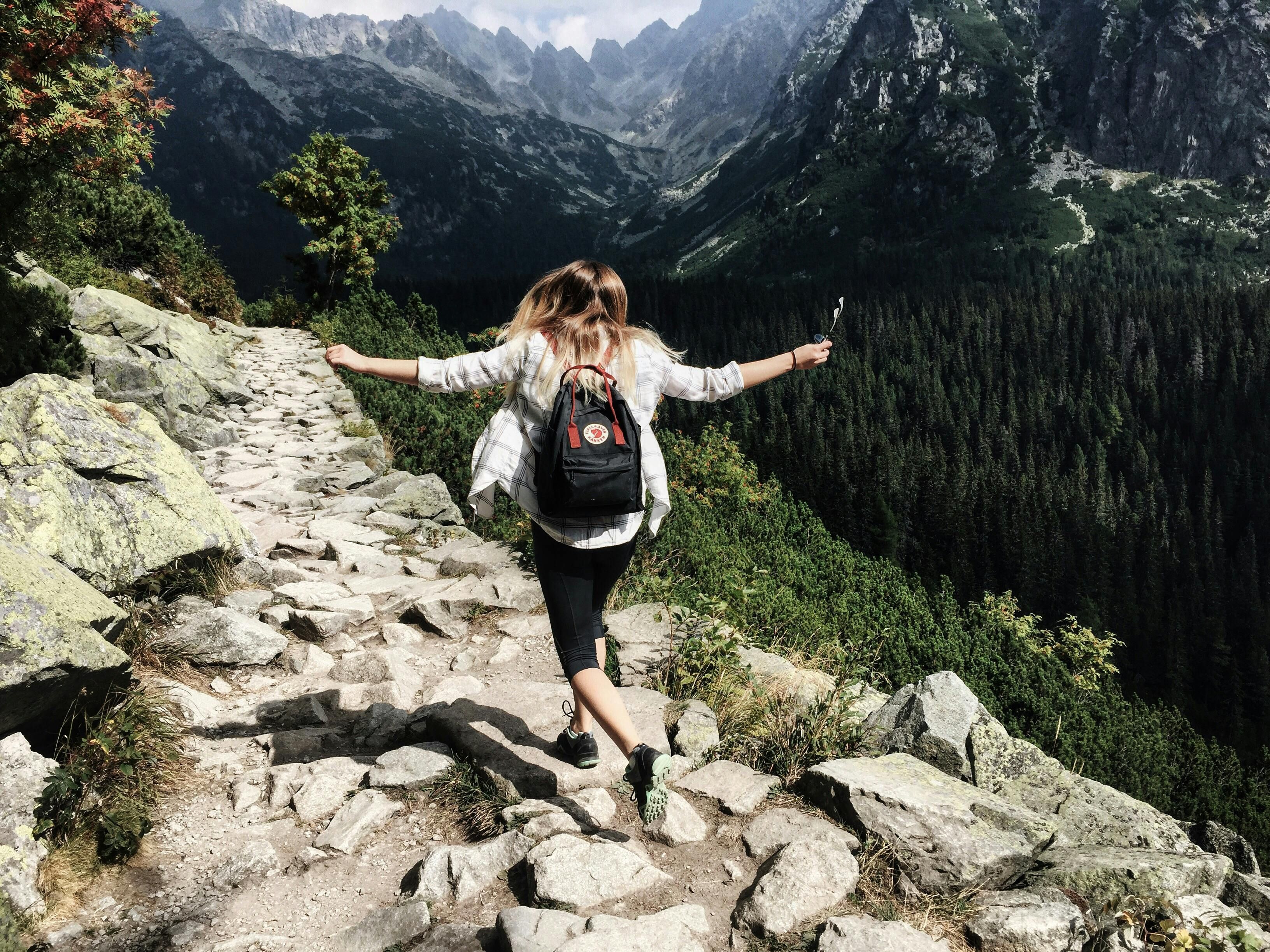 A woman hiking on a trail, focusing on fitness and outdoor adventure.