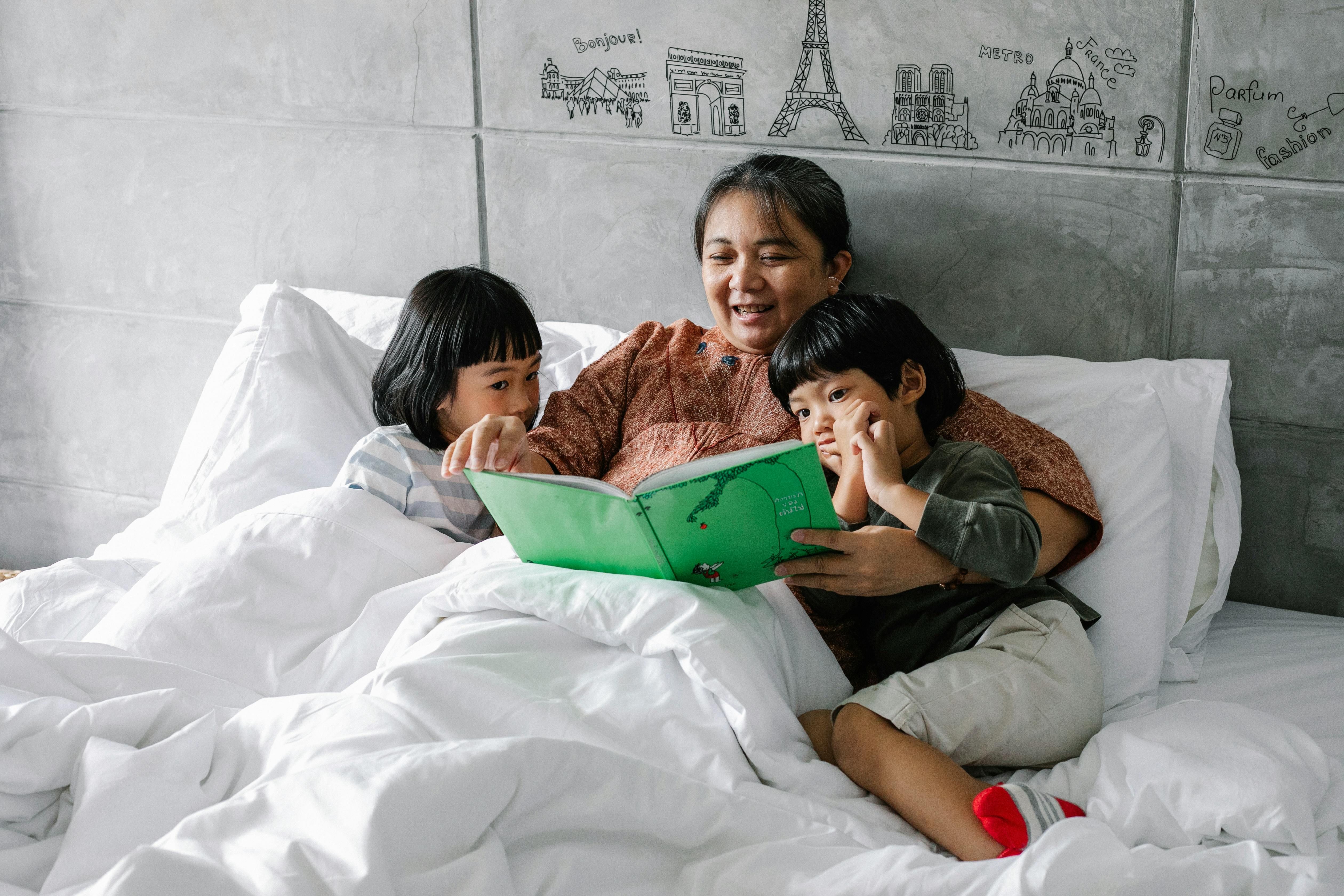 A woman preparing for sleep with her children in a cozy bedroom, creating a calming bedtime routine.