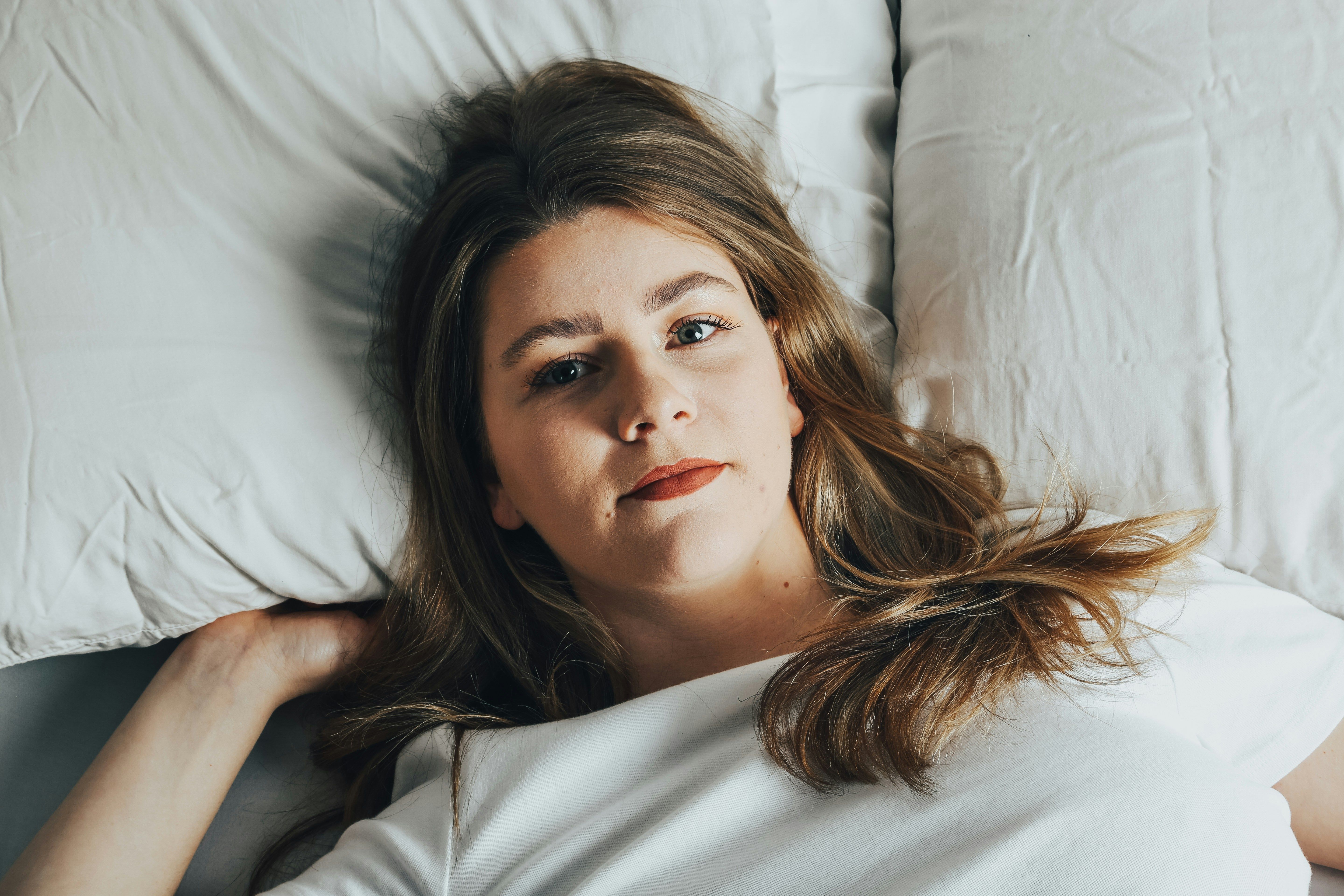 A woman preparing to go to bed, creating a calming nighttime routine to improve sleep quality during intermittent fasting.