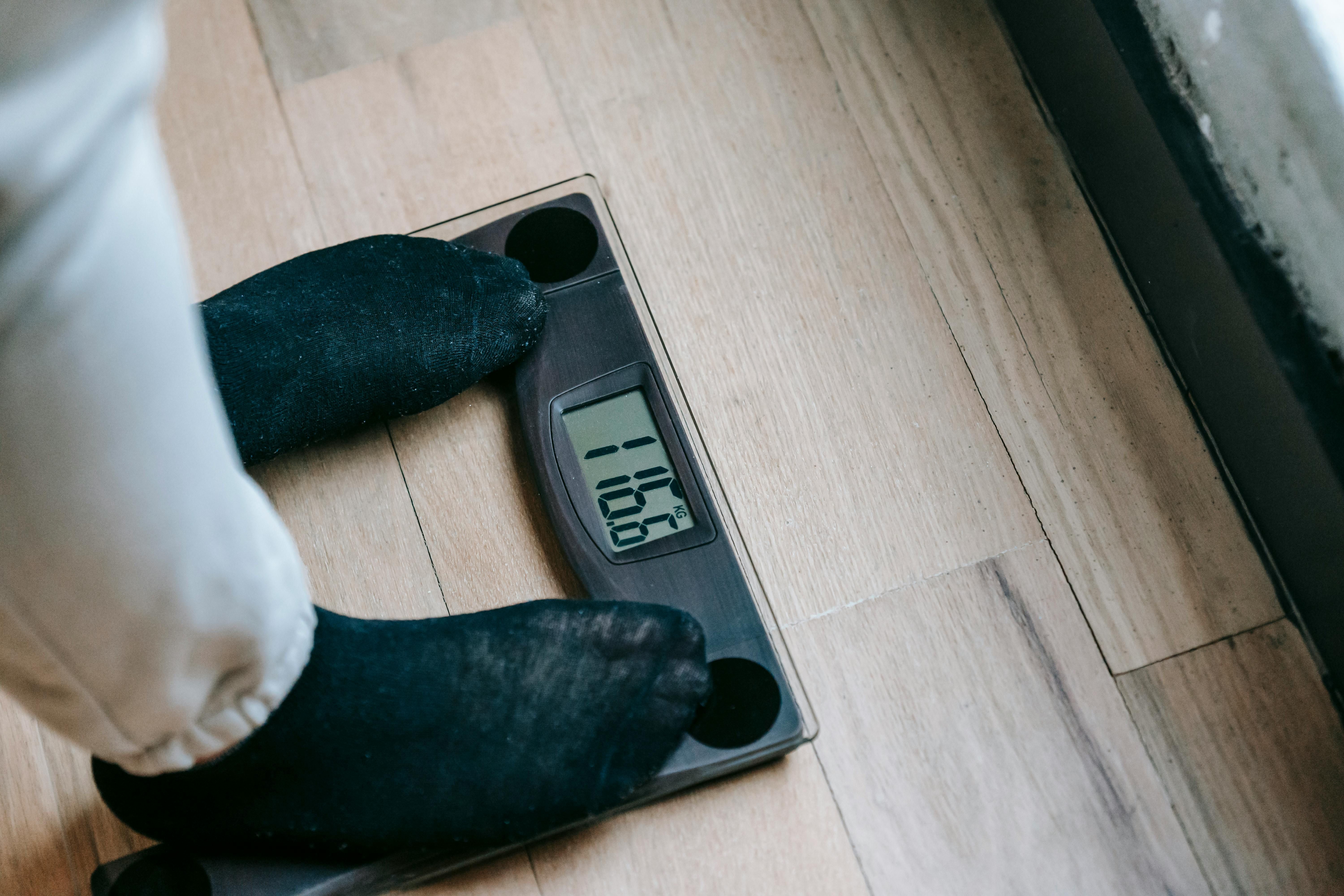 Woman standing on a scale, symbolizing weight management success with intermittent fasting