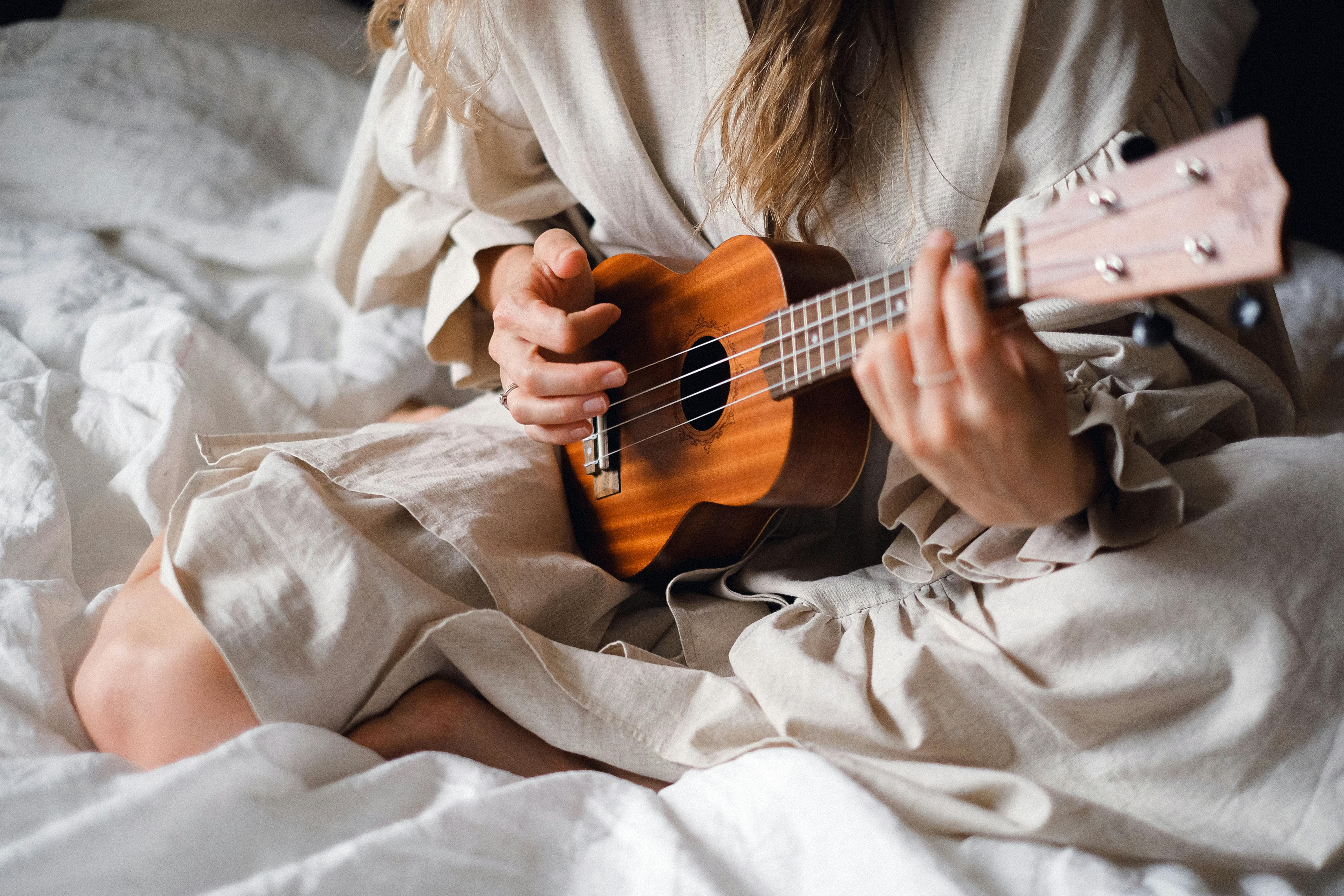 A woman playing the ukulele to enhance cognitive health and emotional well-being through creative expression.