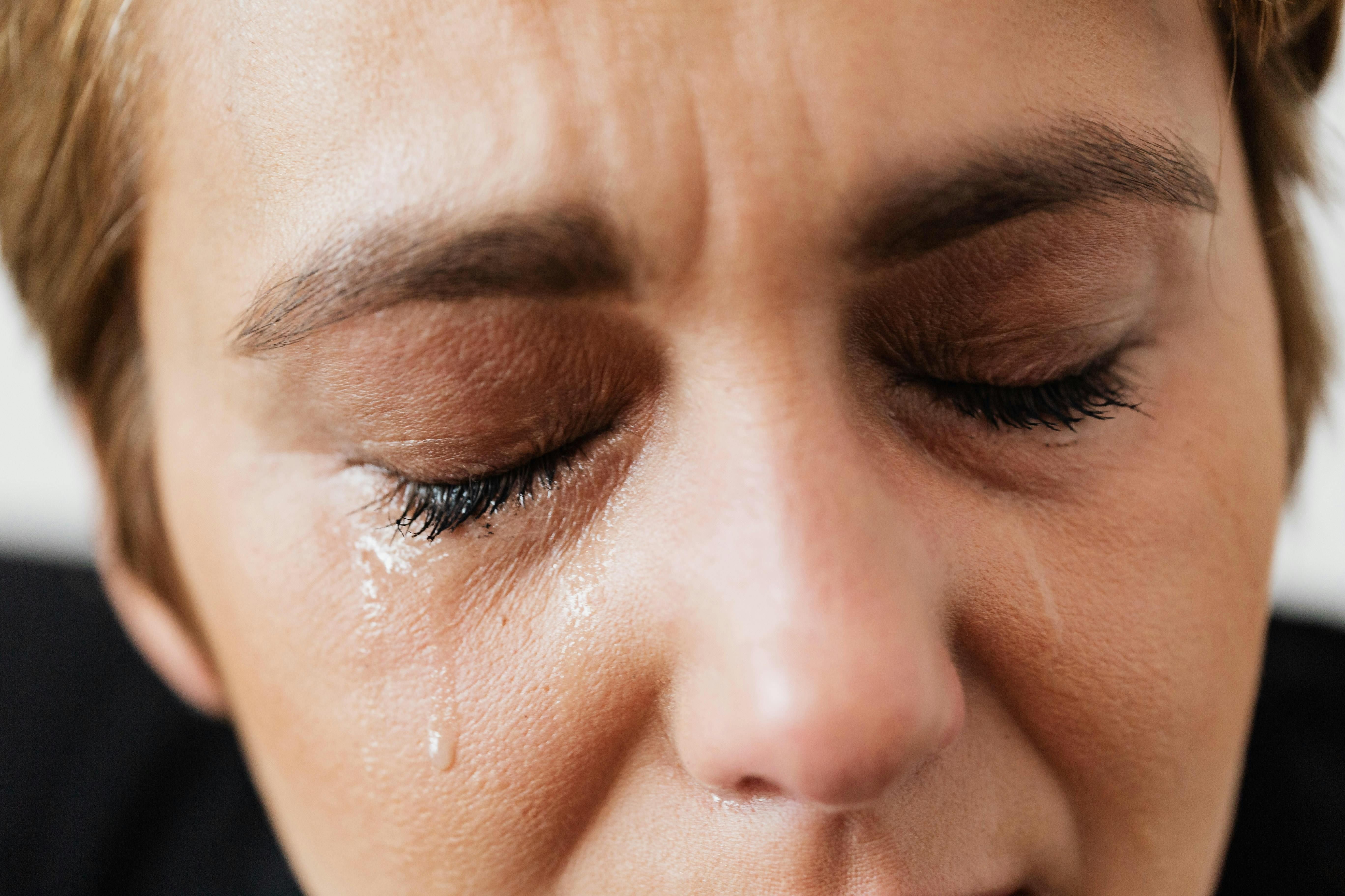 A woman experiencing discomfort from IBS, holding her abdomen in pain.