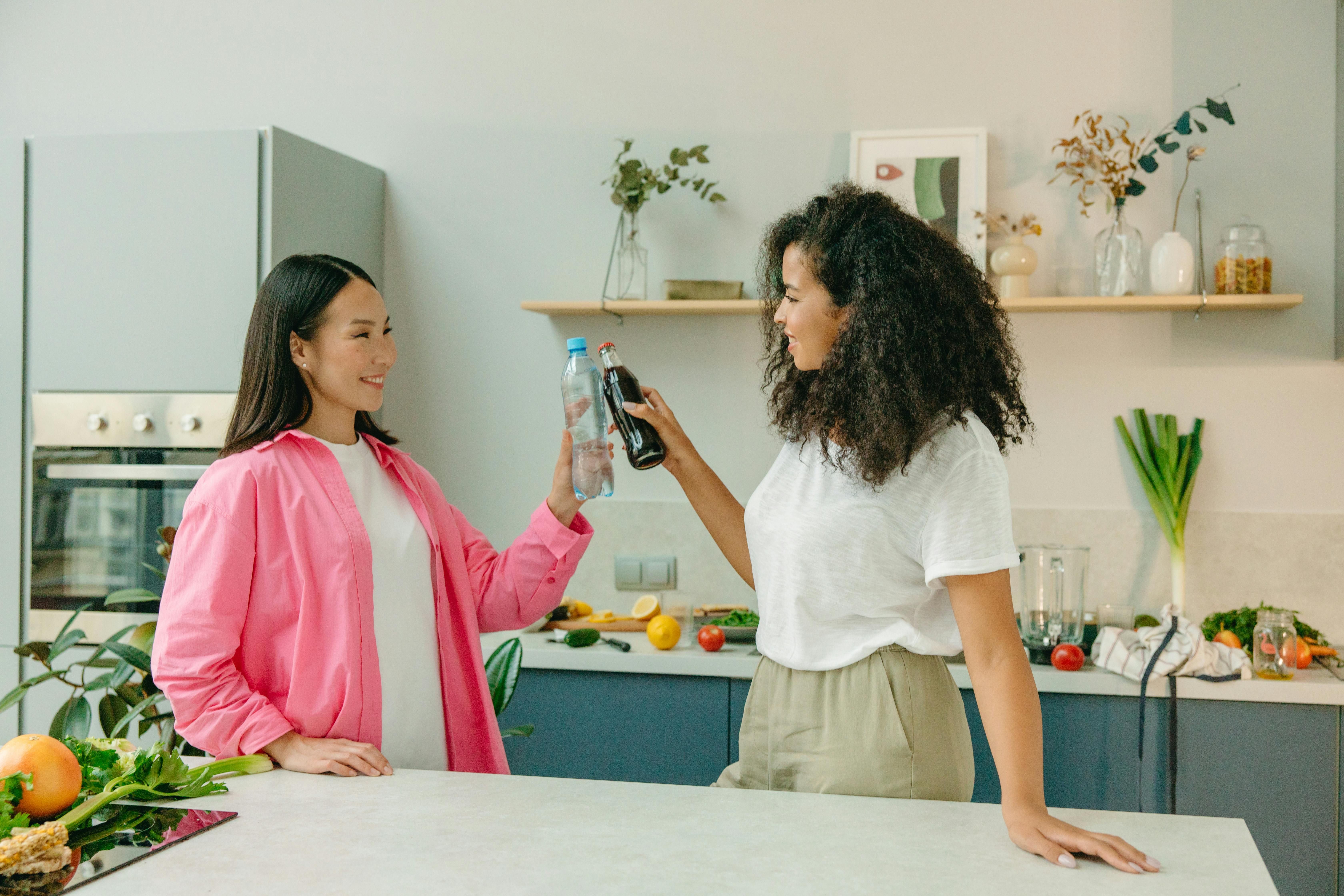 Two women drinking water to prevent headaches while practicing intermittent fasting