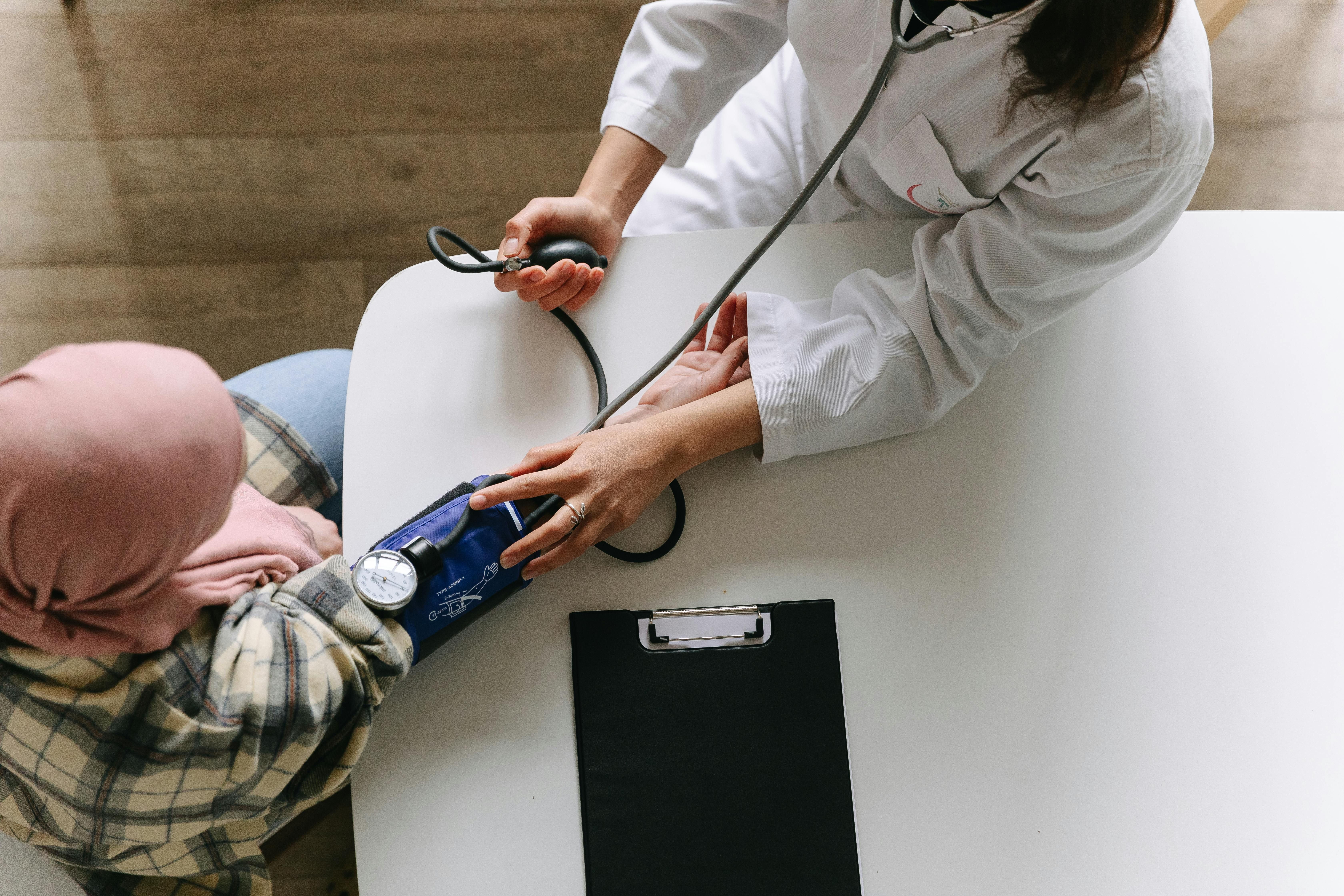 A woman measures another woman's blood pressure while taking metoprolol during an intermittent fast.