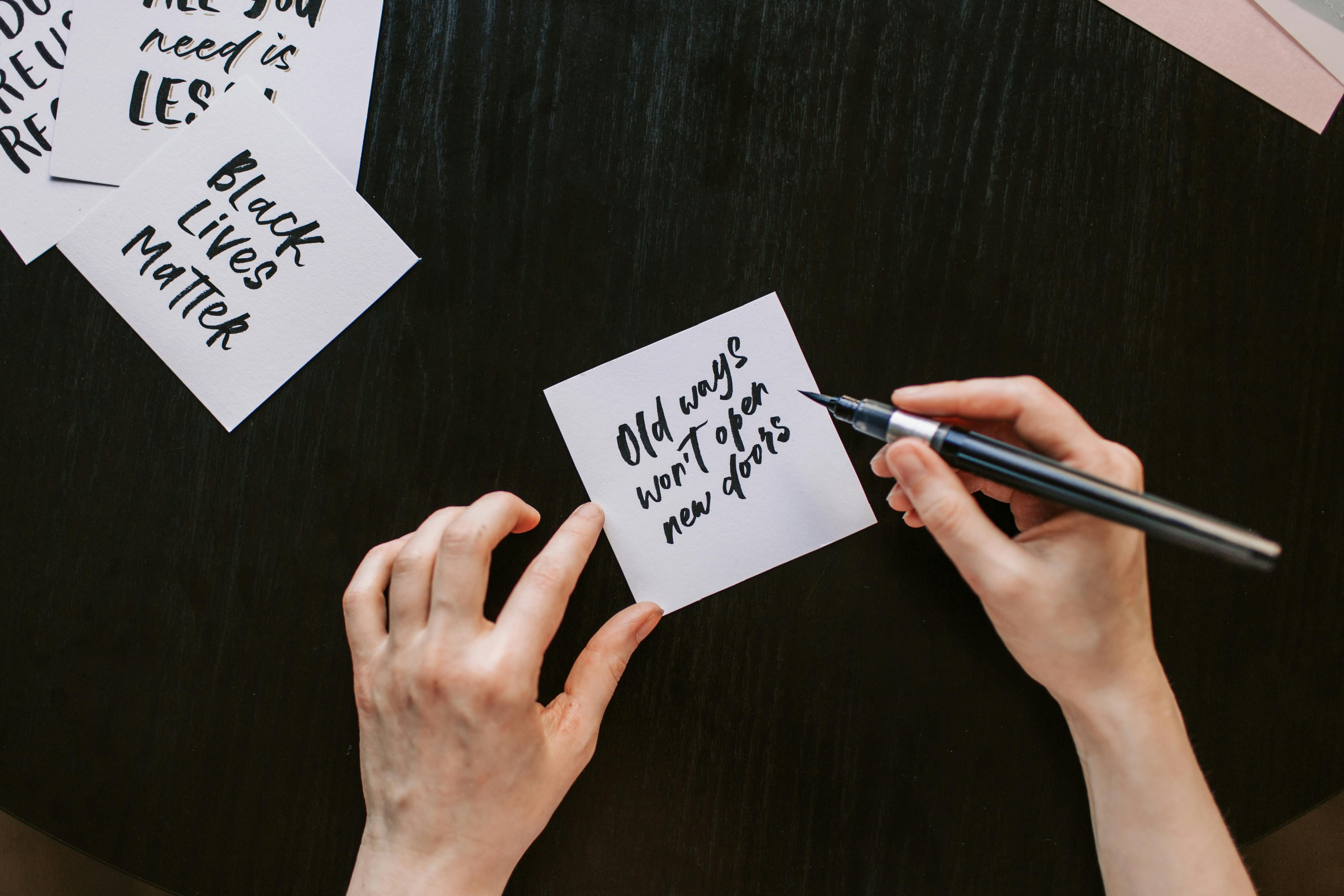 A woman writing positive affirmations to cultivate self-compassion and resilience in her daily life.